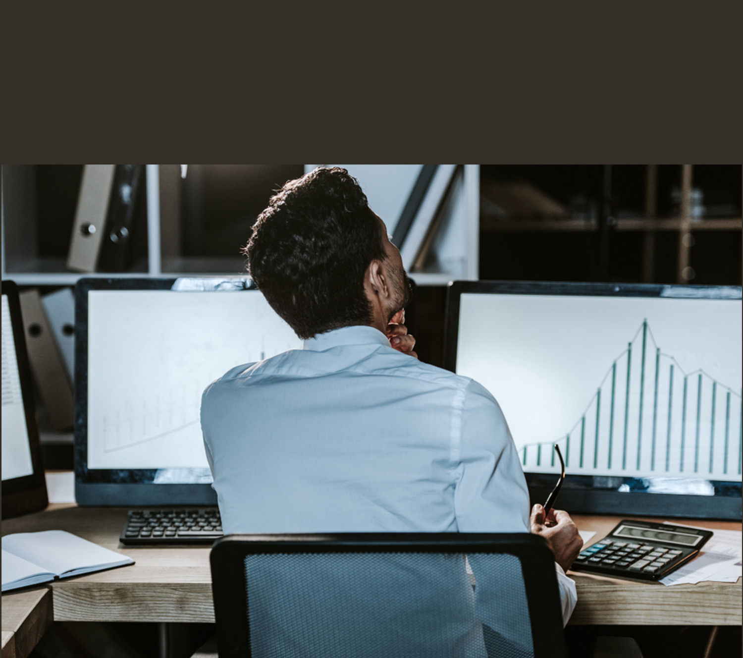 PCを見ながら、悩む男性の画像